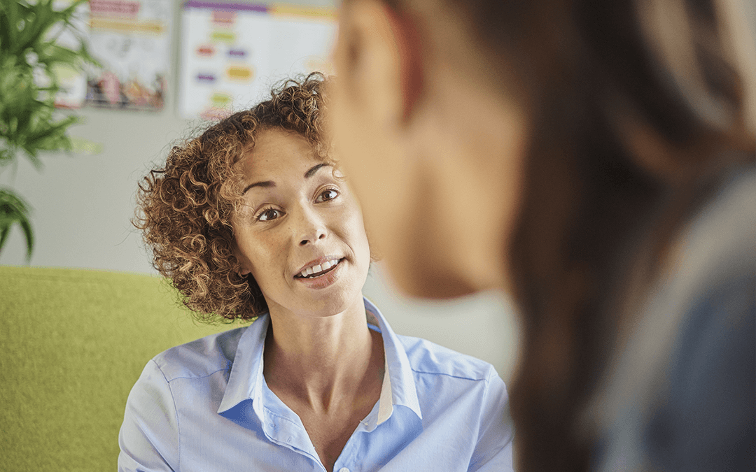 Photo of a mental health and addiction nurse speaking to a teen that is blurred in the foreground. One photo dune infirmière en Santa mental et en toxicomanie aves une étudiante floue en avant.